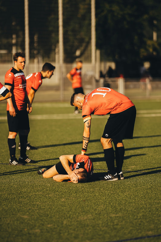 men in red and white jersey shirt playing soccer during daytime