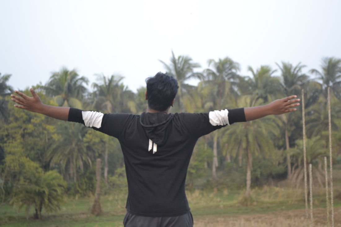 a man standing in a field with his arms outstretched