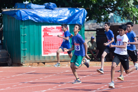 a group of young boys running on a track