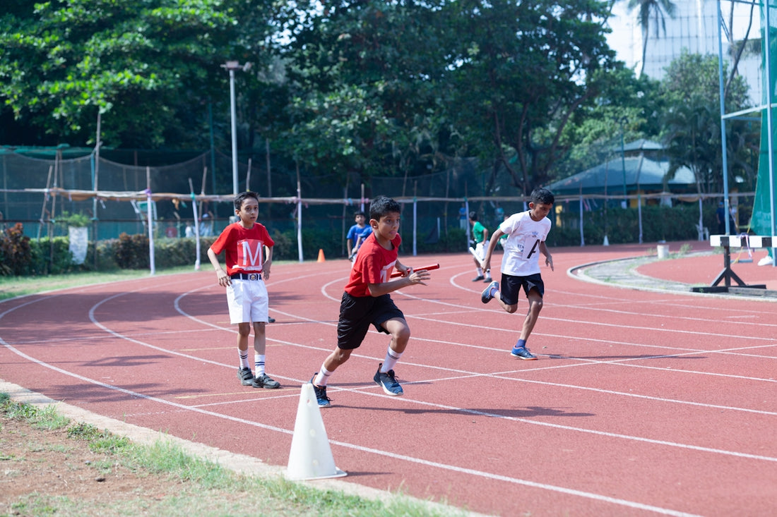 a group of young men running around a track