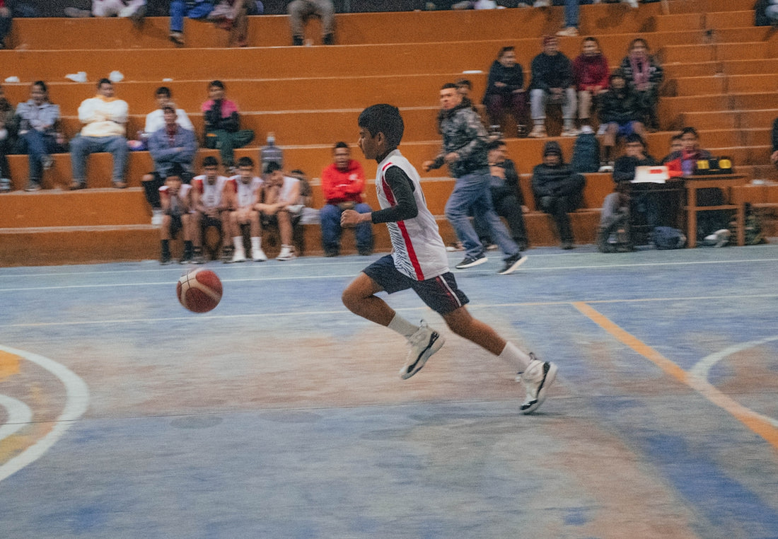 A man dribbling a basketball on a basketball court