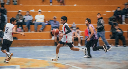 A group of young men playing a game of basketball