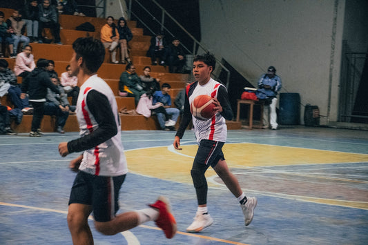 A group of young men playing a game of basketball