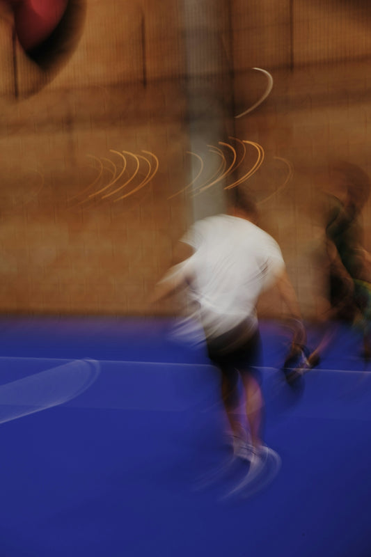 Blurred figures are in motion on a blue surface.