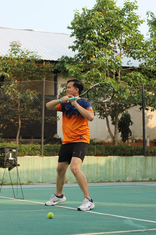 Man swinging tennis racket on court