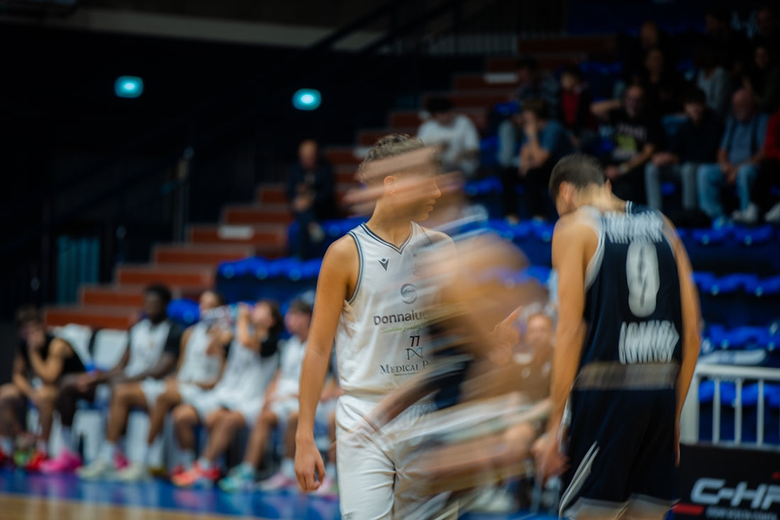 Basketball players during a game with motion blur.