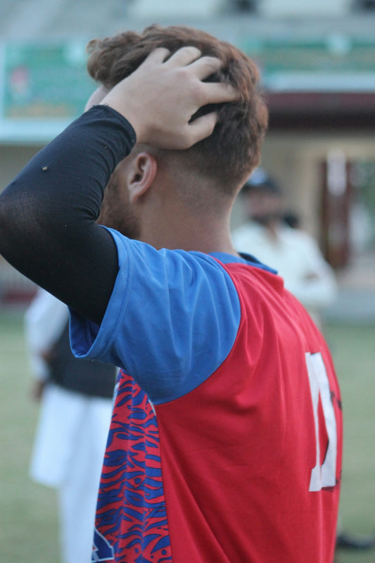 Man adjusting hair during outdoor game