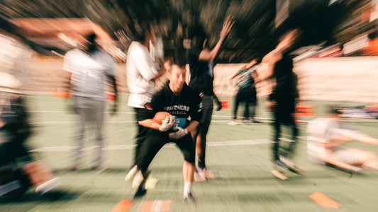 Young athlete holding football with blurred crowd in background